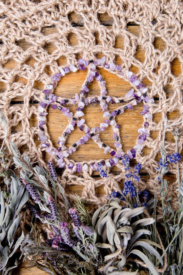 Amethyst Pentagram mit getrockneten Krautbündeln auf Crotchetjutefaser-Altarstoff lizenzfreies stockfoto Amethyst Pentagram mit getrockneten Krautbündeln auf Crotchetjutefaser-Altarstoff lizenzfreies stockfoto