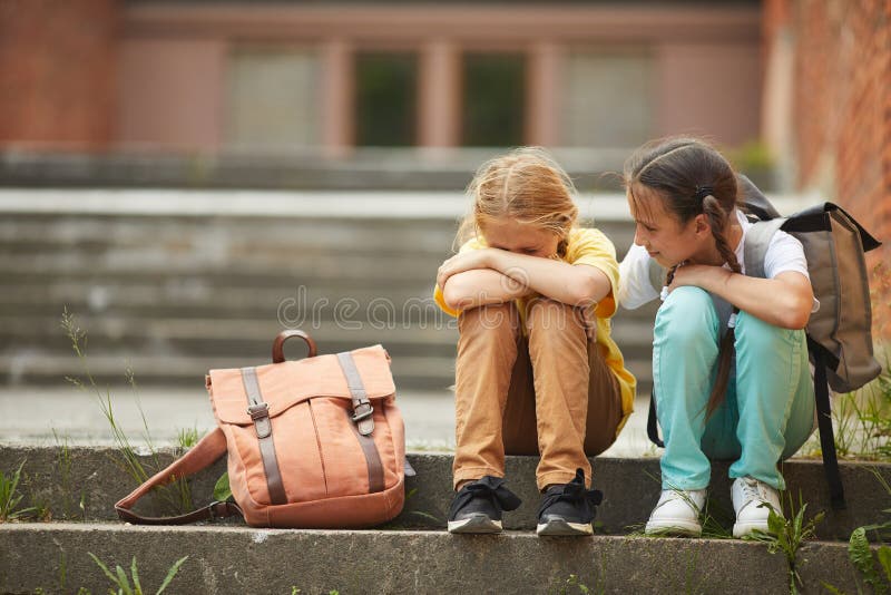 Amica che aiuta una bambina triste a scuola