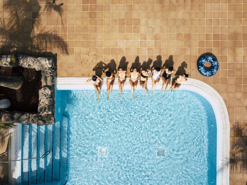 Amiche femmine caucasiche che si approfittano della piscina durante le vacanze estive in albergo o in località turistiche - vista