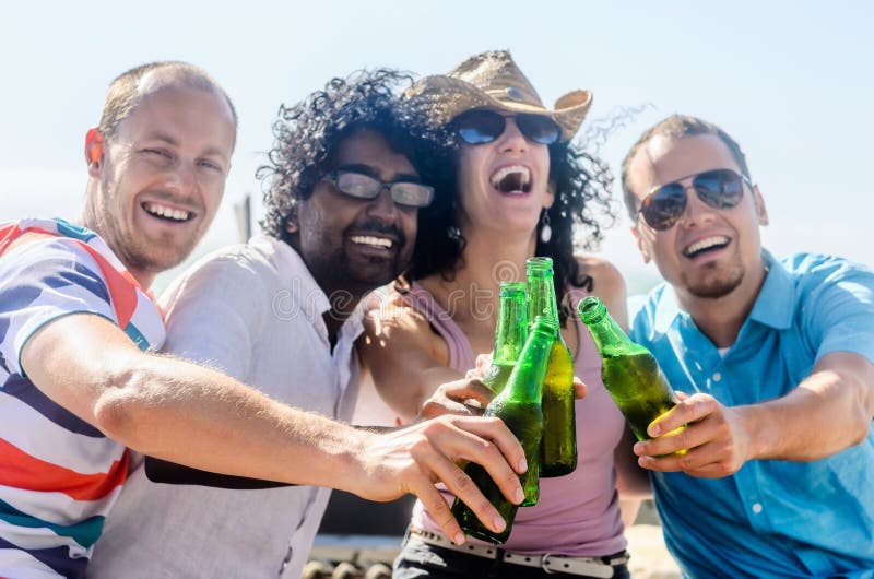 Amici ad un partito della spiaggia che ha bevande immagini stock libere da diritti Amici ad un partito della spiaggia che ha bevande immagini stock libere da diritti