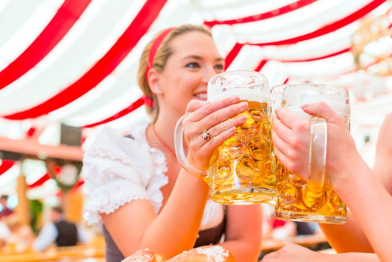 Amici che bevono birra bavarese a Oktoberfest fotografia stock Amici che bevono birra bavarese a Oktoberfest fotografia stock