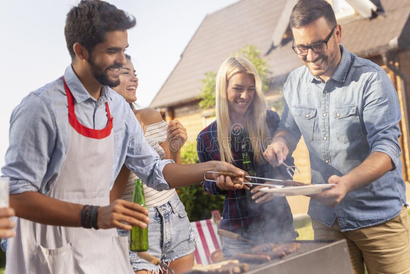 Amici che fanno barbecue immagini stock libere da diritti Amici che fanno barbecue immagini stock libere da diritti