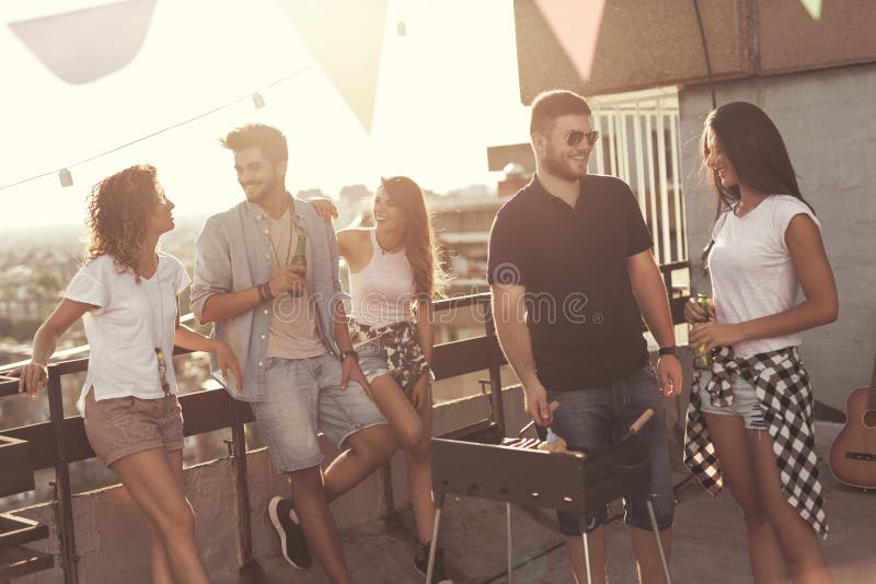 Amici che fanno il barbecue del tetto fotografie stock libere da diritti Amici che fanno il barbecue del tetto fotografie stock libere da diritti