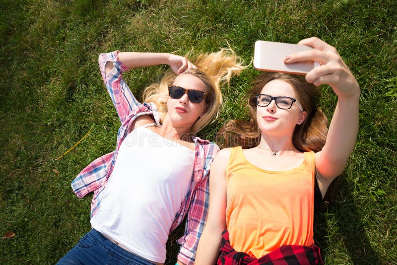 Amici che fanno selfie e che si divertono nel parco Gli adolescenti felici passano insieme il tempo nella città fotografie stock libere da diritti Amici che fanno selfie e che si divertono nel parco Gli adolescenti felici passano insieme il tempo nella città fotografie stock libere da diritti