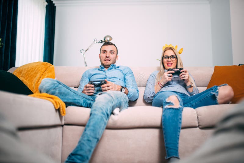 Amici che giocano i video giochi con i regolatori della leva di comando Giovani divertendosi con la tecnologia moderna e giocando fotografia stock libera da diritti Amici che giocano i video giochi con i regolatori della leva di comando Giovani divertendosi con la tecnologia moderna e giocando fotografia stock libera da diritti