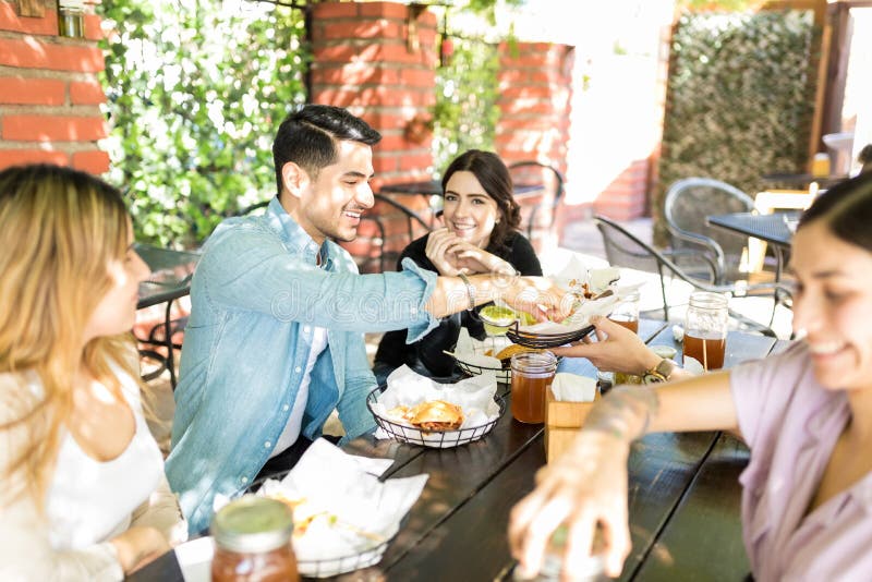 Amici che mangiano gli spuntini durante il raduno sociale fotografie stock Amici che mangiano gli spuntini durante il raduno sociale fotografie stock