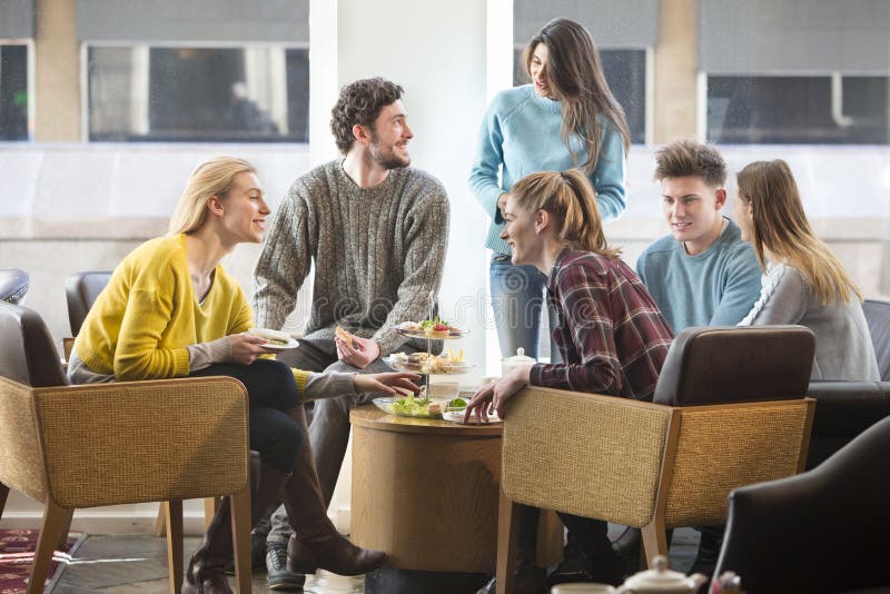 Amici che mangiano il tè di pomeriggio in un caffè immagini stock Amici che mangiano il tè di pomeriggio in un caffè immagini stock
