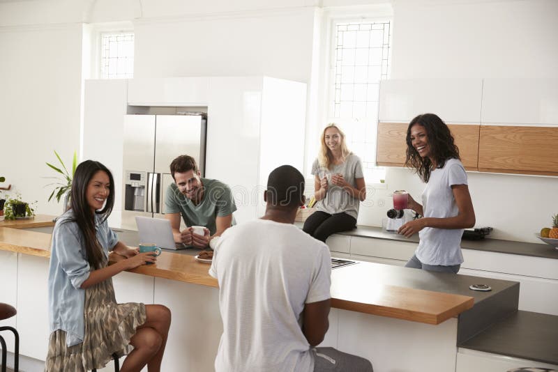 Friends Talking And Drinking Coffee In Modern Kitchen. Friends Talking And Drinking Coffee In Modern Kitchen