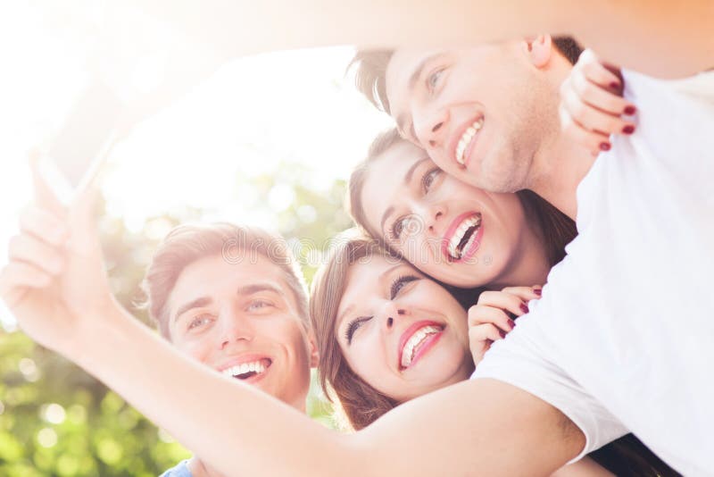 Amici che prendono un selfie con lo smartphone immagine stock Amici che prendono un selfie con lo smartphone immagine stock