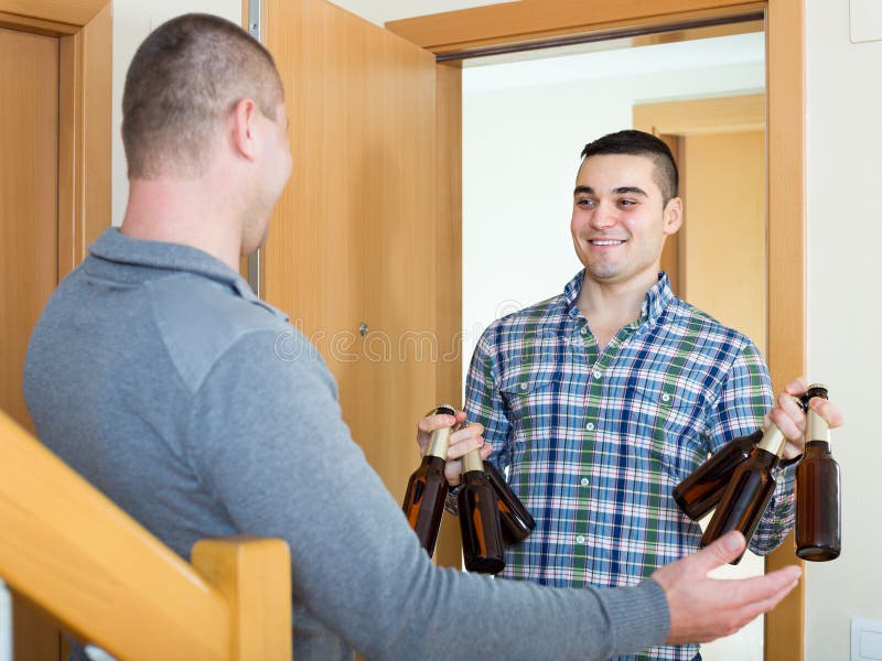 Amici che si riuniscono per bere birra a casa fotografia stock libera da diritti Amici che si riuniscono per bere birra a casa fotografia stock libera da diritti