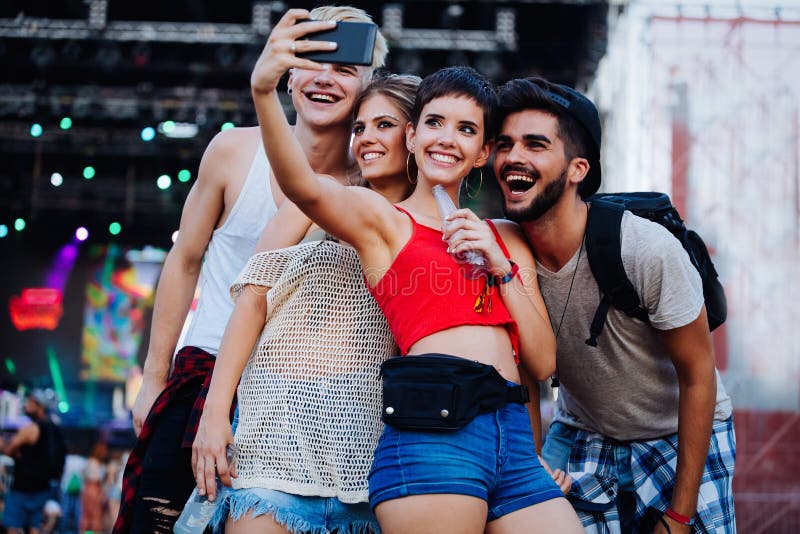 Amici felici che prendono selfie al festival di musica