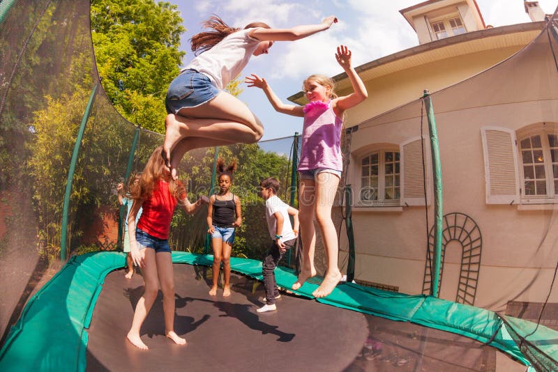 Amici felici che rimbalzano sul trampolino all'aperto fotografia stock libera da diritti Amici felici che rimbalzano sul trampolino all'aperto fotografia stock libera da diritti