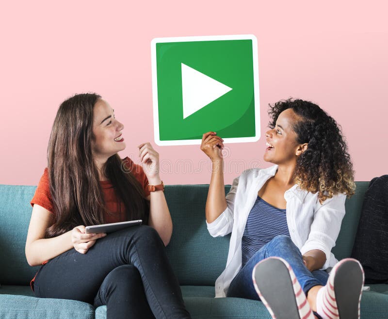 Amici femminili che tengono un tasto di riproduzione immagine stock libera da diritti Amici femminili che tengono un tasto di riproduzione immagine stock libera da diritti