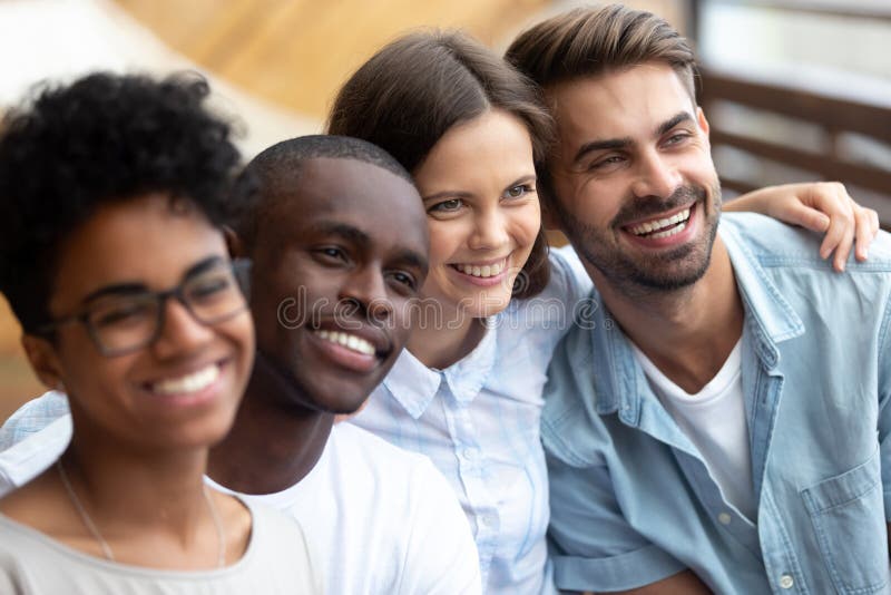 Amici multietnici felici che posano insieme per la foto vicino su immagine stock libera da diritti Amici multietnici felici che posano insieme per la foto vicino su immagine stock libera da diritti