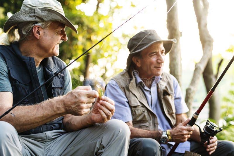 Amici senior che pescano dal lago