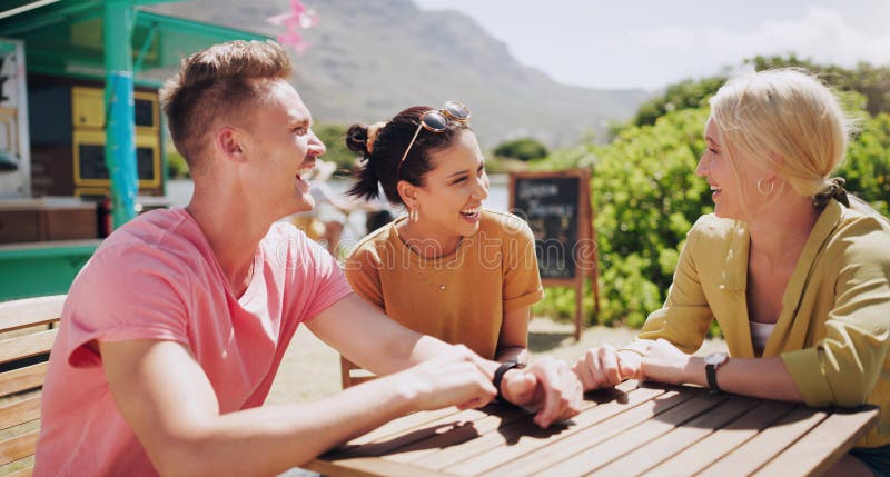 Funny, friends and talking at outdoor table of restaurant, communication and happy people bonding together. Group, smile and laughing at conversation in nature for comedy, joke or story in summer. Funny, friends and talking at outdoor table of restaurant, communication and happy people bonding together. Group, smile and laughing at conversation in nature for comedy, joke or story in summer.