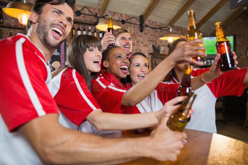 Amigos alegres que parecen ausentes mientras que sostiene las botellas de cerveza foto de archivo libre de regalías Amigos alegres que parecen ausentes mientras que sostiene las botellas de cerveza foto de archivo libre de regalías