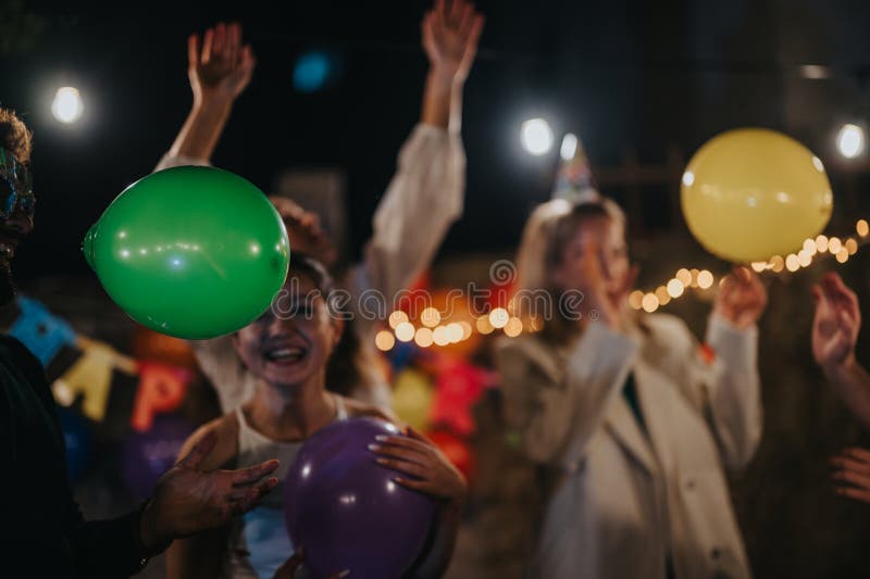 Amigos celebrando un cumpleaños con globos y decoraciones en un patio trasero foto de archivo libre de regalías