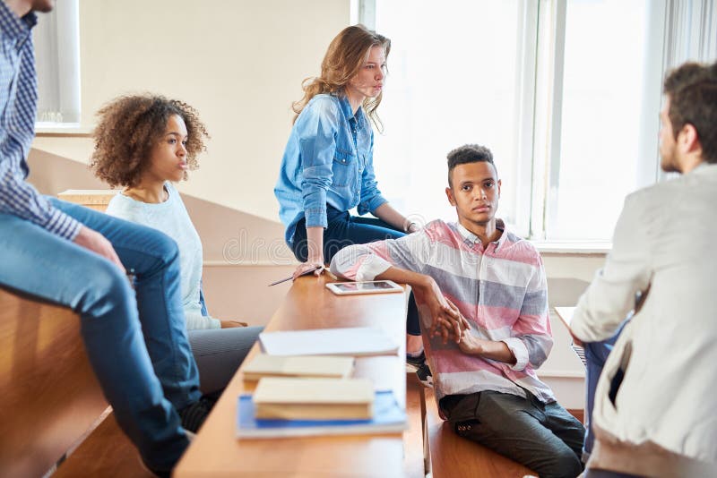 Amigos de los estudiantes que charlan antes de clase de la universidad imágenes de archivo libres de regalías Amigos de los estudiantes que charlan antes de clase de la universidad imágenes de archivo libres de regalías