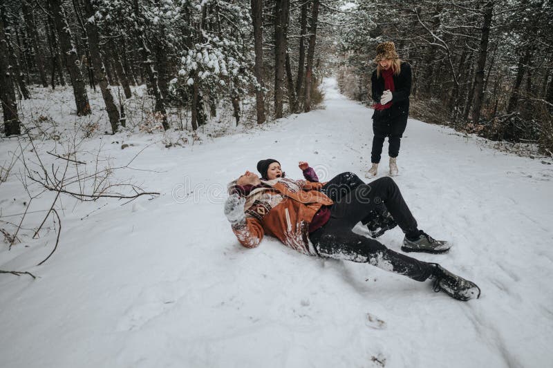 Amigos disfrutando de la nieve en un bosque de invierno fotos de archivo