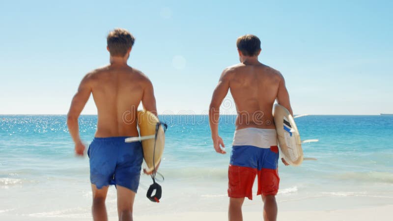 Amigos felices de la persona que practica surf en la playa