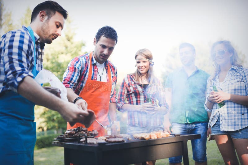 Amigos felices que disfrutan del partido de la barbacoa imagenes de archivo Amigos felices que disfrutan del partido de la barbacoa imagenes de archivo
