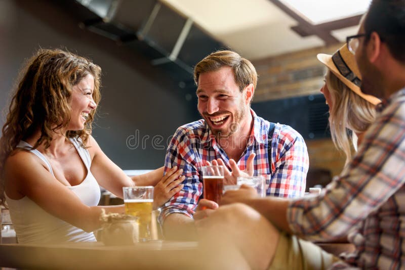 Amigos felices que se divierten en la barra - cerveza de consumición de la gente de moda joven y que ríen junto fotografía de archivo Amigos felices que se divierten en la barra - cerveza de consumición de la gente de moda joven y que ríen junto fotografía de archivo
