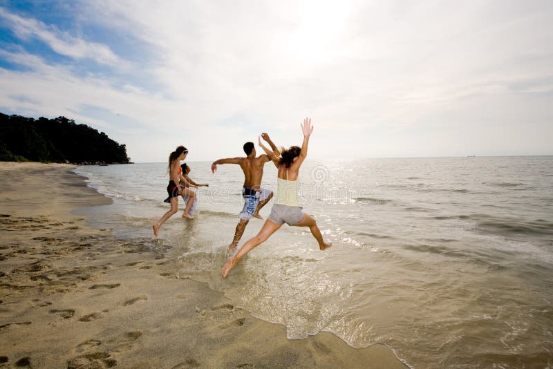 Happy friends having fun by the beach jumping into the sea. Happy friends having fun by the beach jumping into the sea