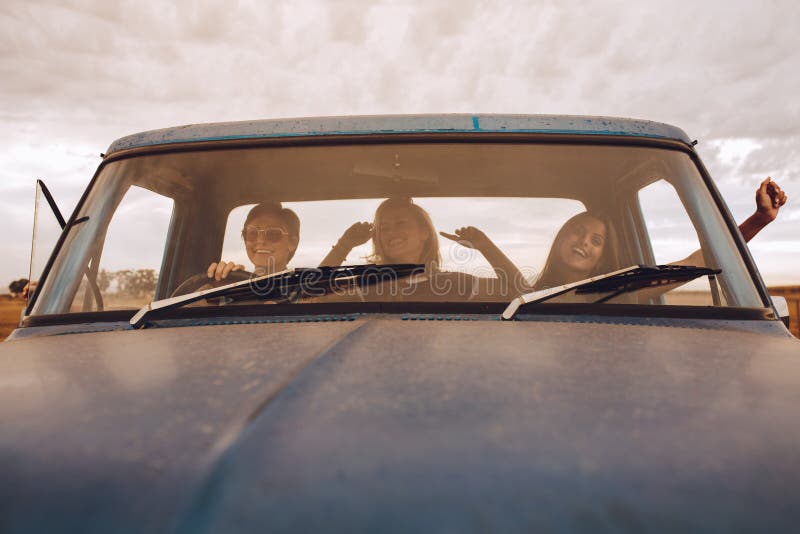 Amigos fêmeas que têm o divertimento na viagem por estrada fotos de stock Amigos fêmeas que têm o divertimento na viagem por estrada fotos de stock