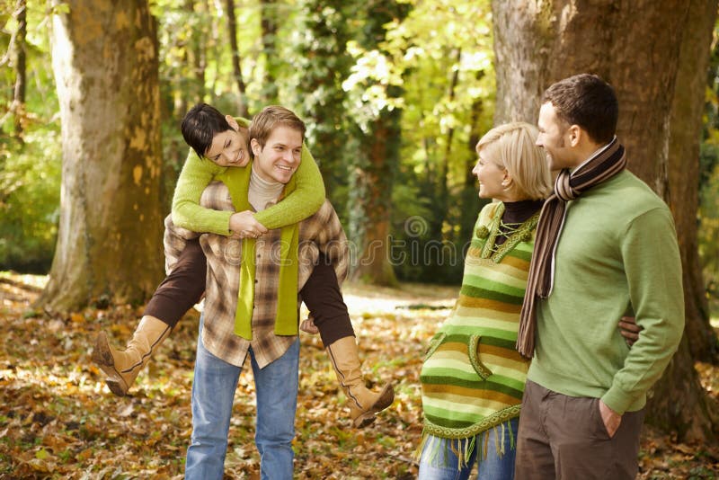 Amigos jovenes que se divierten en parque del otoño foto de archivo libre de regalías Amigos jovenes que se divierten en parque del otoño foto de archivo libre de regalías