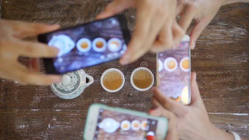 Amigos jovenes que toman la foto de la ceremonia de té del chino tradicional con el teléfono móvil Opinión de consumición del té