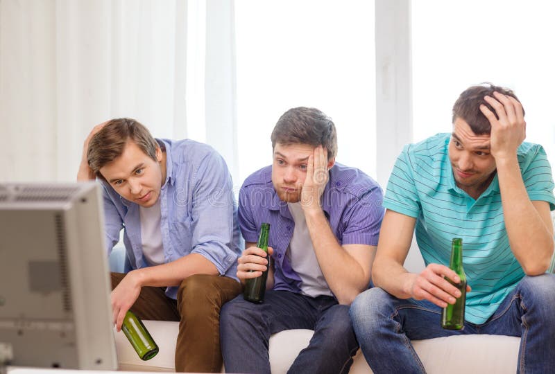 Amigos masculinos tristes com esportes de observação da cerveja imagens de stock royalty free Amigos masculinos tristes com esportes de observação da cerveja imagens de stock royalty free