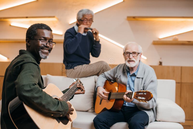 Amigos mayores que juegan música imágenes de archivo libres de regalías Amigos mayores que juegan música imágenes de archivo libres de regalías