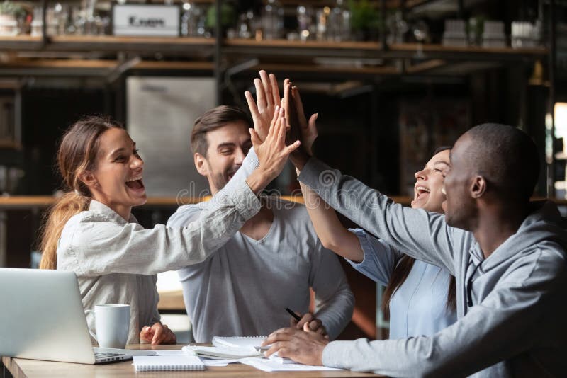 Amigos milenares diversos dos estudantes extáticos que comemoram o revestimento do estudo imagens de stock Amigos milenares diversos dos estudantes extáticos que comemoram o revestimento do estudo imagens de stock