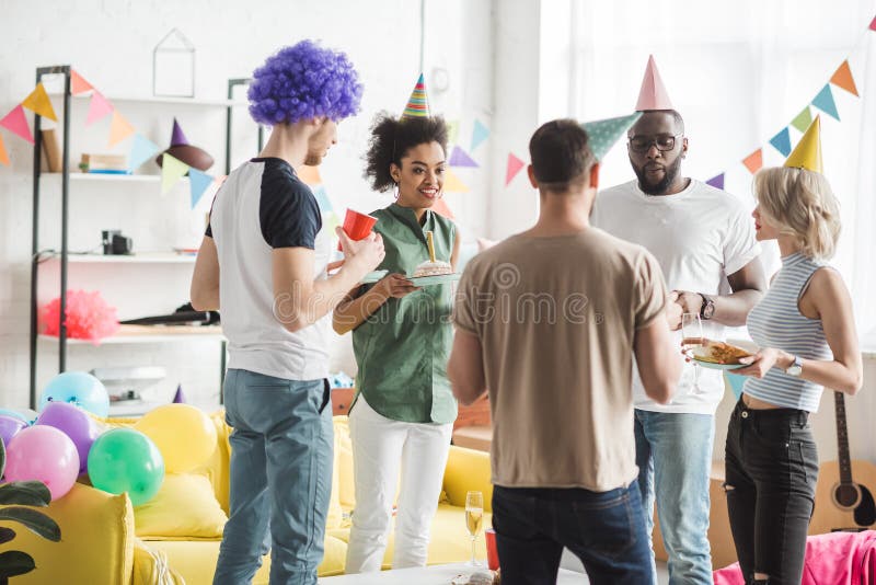 Amigos multirraciales que celebran cumpleaños con las bebidas imagen de archivo Amigos multirraciales que celebran cumpleaños con las bebidas imagen de archivo