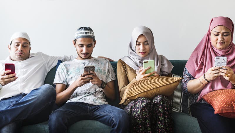 Amigos muçulmanos que usam meios sociais em telefones fotos de stock Amigos muçulmanos que usam meios sociais em telefones fotos de stock