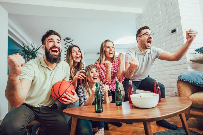 Conceitual assistir jogo de futebol no sofá na televisão com garrafas de  cerveja e tigela de pipoca em amigos apreciando jogo de futebol TV fotos,  imagens de © TheVisualsYouNeed #193389504