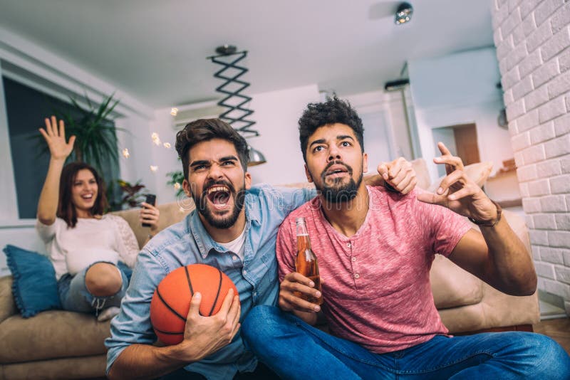 Conceitual assistir jogo de futebol no sofá na televisão com garrafas de  cerveja e tigela de pipoca em amigos apreciando jogo de futebol TV fotos,  imagens de © TheVisualsYouNeed #193389504