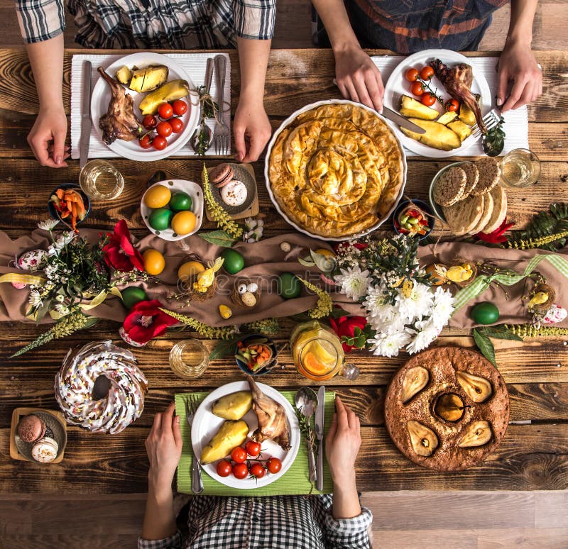 Amigos ou família do feriado na tabela do feriado com carne do coelho, vegetais, tortas, ovos, vista superior imagens de stock Amigos ou família do feriado na tabela do feriado com carne do coelho, vegetais, tortas, ovos, vista superior imagens de stock