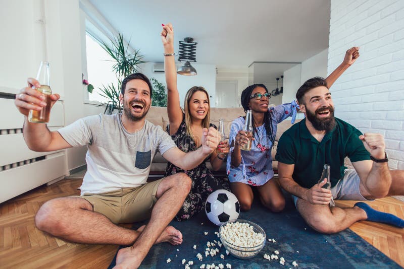 Conceitual assistir jogo de futebol no sofá na televisão com garrafas de  cerveja e tigela de pipoca em amigos apreciando jogo de futebol TV fotos,  imagens de © TheVisualsYouNeed #193389504