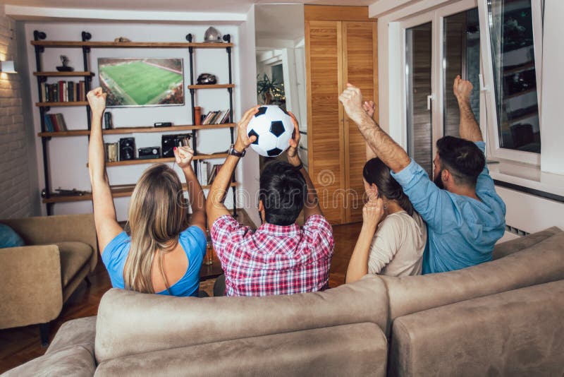 Conceitual assistir jogo de futebol no sofá na televisão com garrafas de  cerveja e tigela de pipoca em amigos apreciando jogo de futebol TV fotos,  imagens de © TheVisualsYouNeed #193389504