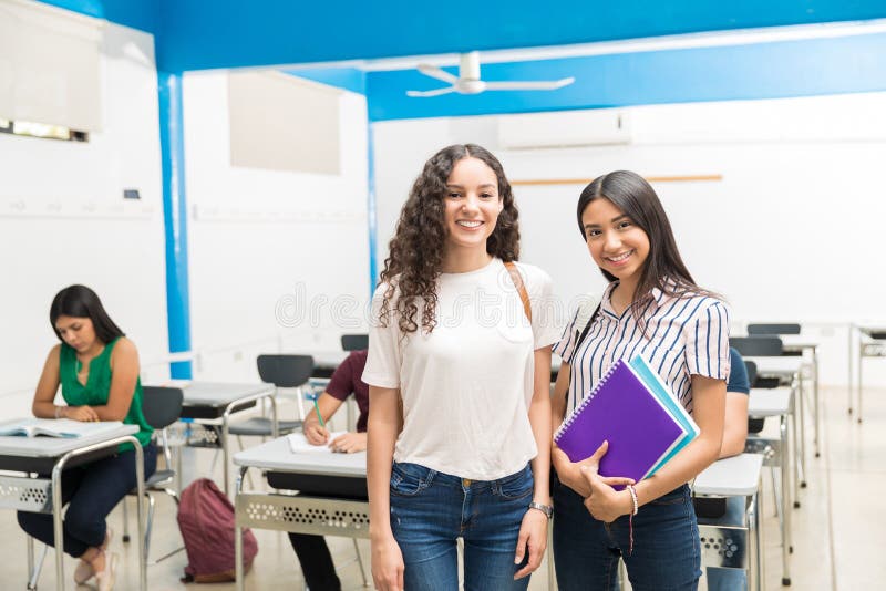Smiling teenager friends standing in university class. Smiling teenager friends standing in university class