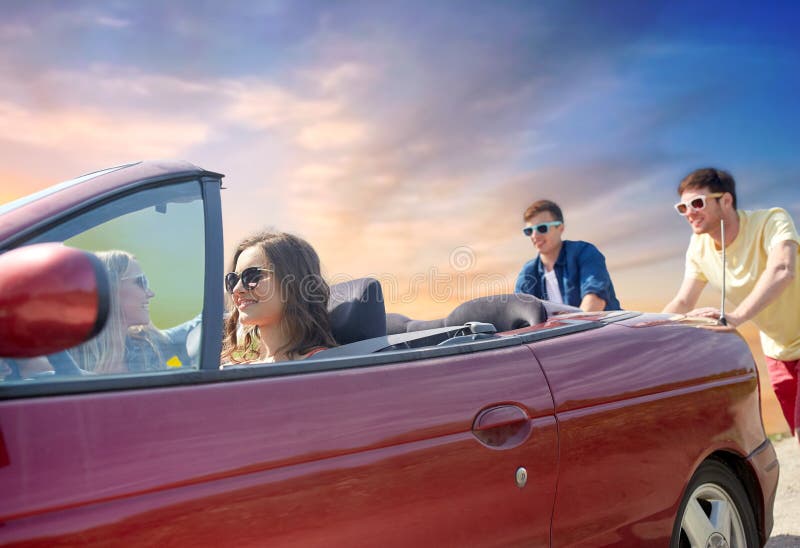 Amigos que empujan el coche convertible roto foto de archivo libre de regalías Amigos que empujan el coche convertible roto foto de archivo libre de regalías
