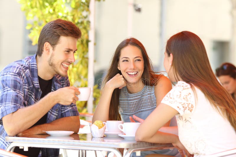 Three happy friends talking and laughing in a coffee shop terrace. Three happy friends talking and laughing in a coffee shop terrace