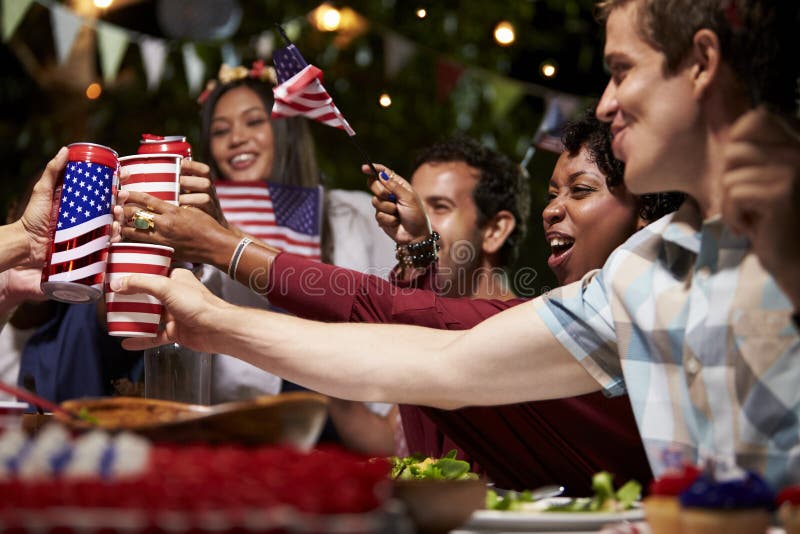 Amigos que fazem um brinde para comemorar o 4o do feriado de julho imagens de stock Amigos que fazem um brinde para comemorar o 4o do feriado de julho imagens de stock