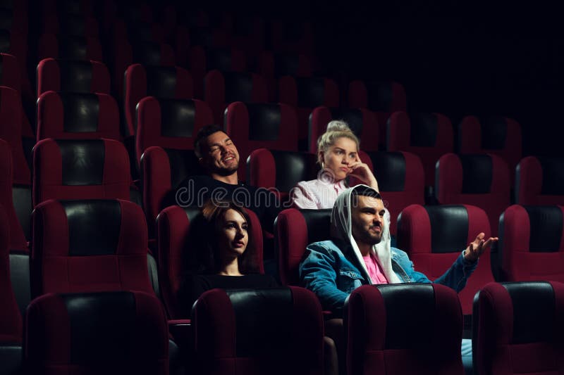 Amigos que olham o filme no teatro do cinema fotos de stock Amigos que olham o filme no teatro do cinema fotos de stock