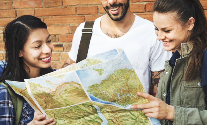 Amigos que verificam o mapa para ver se há sentidos imagem de stock royalty free Amigos que verificam o mapa para ver se há sentidos imagem de stock royalty free