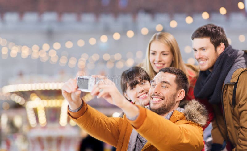 Amigos tomando selfie con cámara en navidad imagenes de archivo
