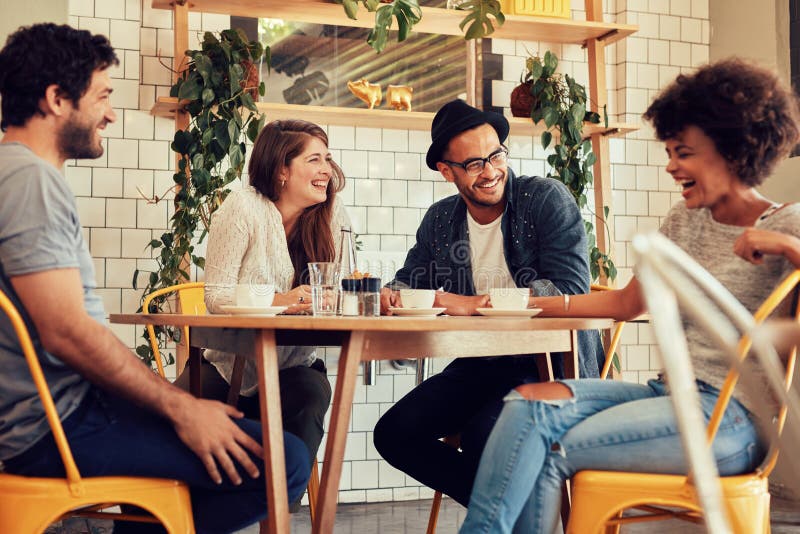 Young people having a great time in cafe. Friends smiling and sitting in a coffee shop, drinking coffee and enjoying together. Young people having a great time in cafe. Friends smiling and sitting in a coffee shop, drinking coffee and enjoying together.