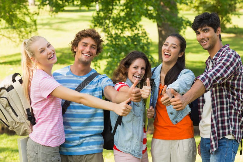 Group portrait of happy college friends gesturing thumbs up in the campus. Group portrait of happy college friends gesturing thumbs up in the campus